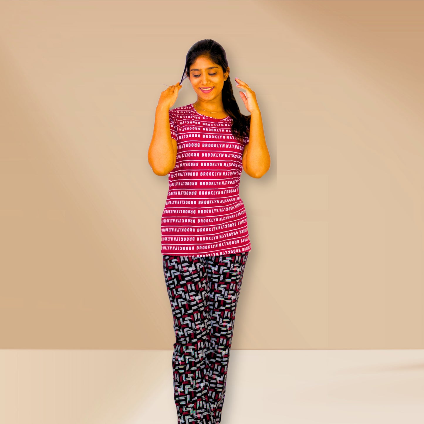 लाल रंग की टेक्स्ट प्रिंट वाली तथा काली एम एंड एम नाइट ड्रेस।