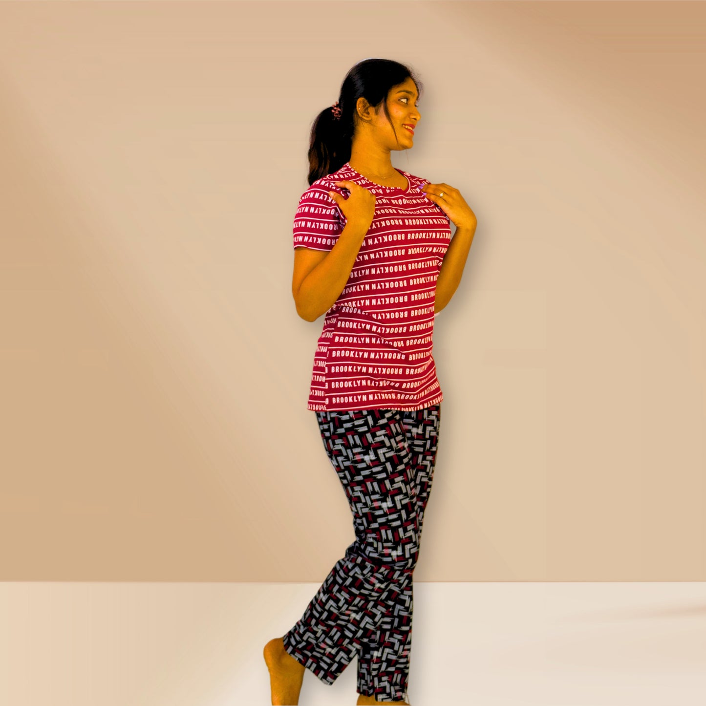 लाल रंग की टेक्स्ट प्रिंट वाली तथा काली एम एंड एम नाइट ड्रेस।