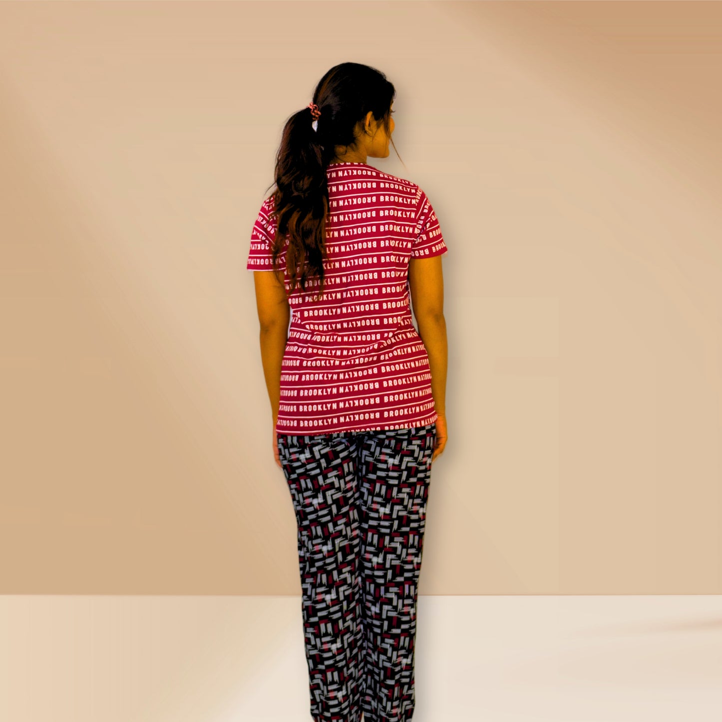 लाल रंग की टेक्स्ट प्रिंट वाली तथा काली एम एंड एम नाइट ड्रेस।